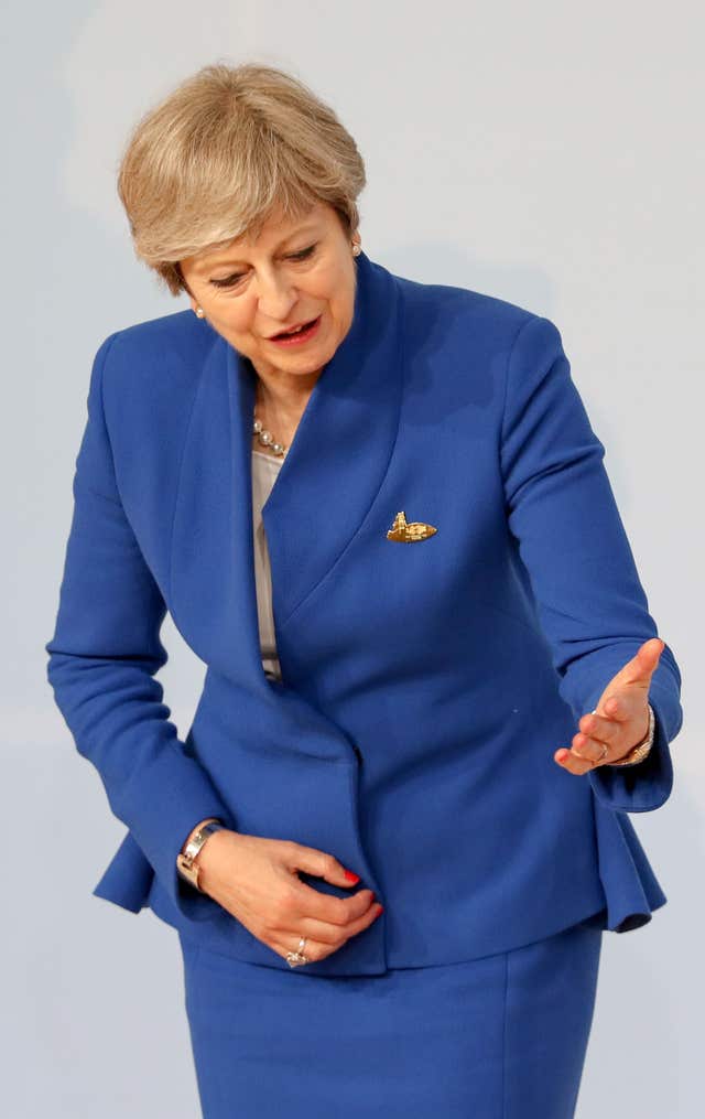 Theresa May looks as though she plays air guitar at the G20 (Matt Cardy/PA)