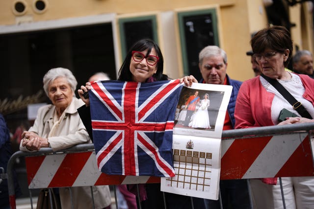 A royal fan holds a Union flag as she awaits the arrival of the Princess of Wales
