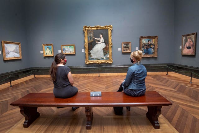 Visitors wearing PPE sit apart at the National Gallery