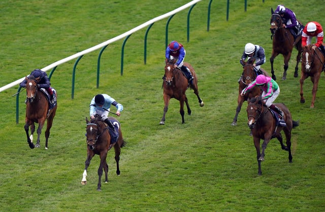 Prosperous Voyage (pink cap) chases Cachet in the 1000 Guineas at Newmarket 
