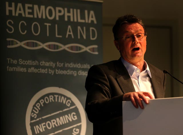 Bill Wright speaking from lectern with a background that reads Haemophilia Scotland