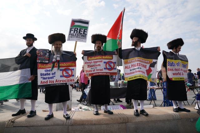 Five men wearing Jewish religious clothing