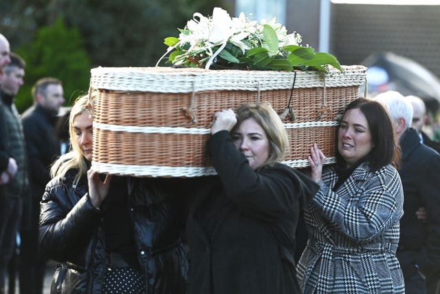 Friends carry Natalie McNally's casket following her funeral service in December 2022 
