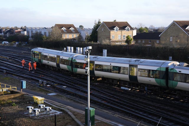 Engineers work on a derailed Southern train at Selhurst train depot in south-east London