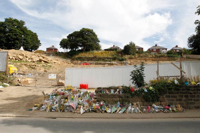 Floral tributes outside the building site (PA)