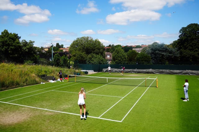 Emma Raducanu serves to Katie Boulter during a practice session at the All England Club