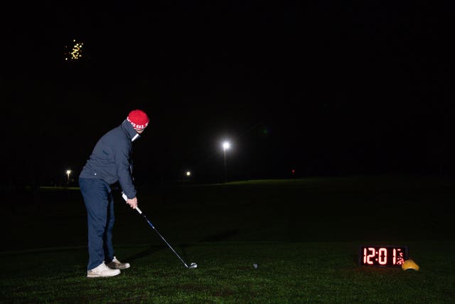 Richard Silk takes the first tee shot with a neon coloured ball whilst under floodlights at Morley Hayes Golf centre