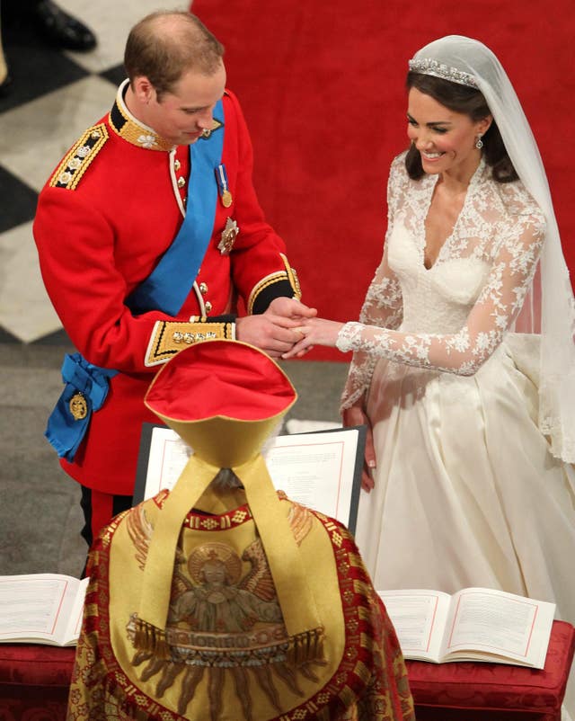 Kate smiles as William tries to put the ring on her finger (Andrew Milligan/PA)