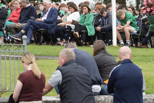 Mourners seated in the church grounds for the funeral for Vanessa Whyte and her children Sara and James Rutledge, at Church of the Immaculate Conception in Barefield, Co Clare.
