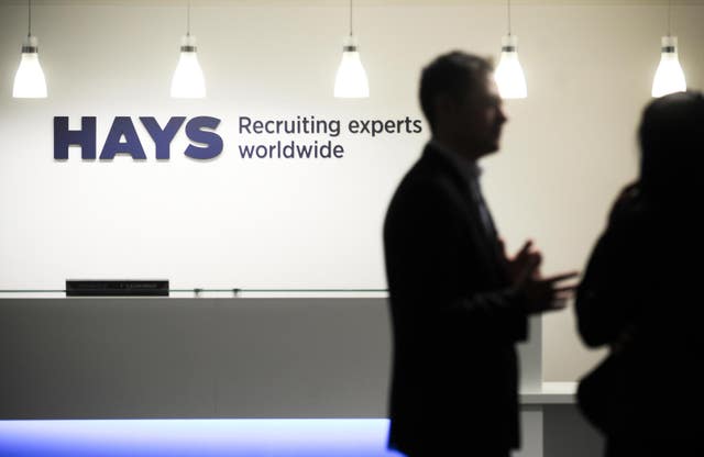 Hays signage on wall behind silhouette of businesspeople