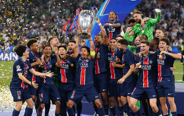 Paris St Germain’s Marquinhos lifts the Champions League trophy in front of celebrating team-mates