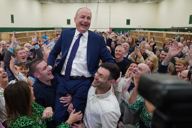 Fianna Fail leader Micheal Martin is hoisted up by his sons