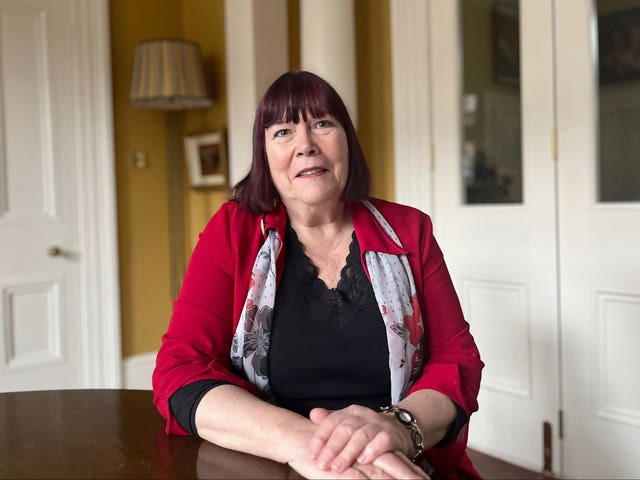 Bronagh Hinds sitting at a table in a house