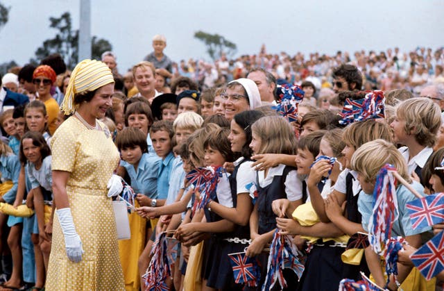 The Queen meets flag-waving school children in Brisbane during her Silver Jubilee Tour of Australia 