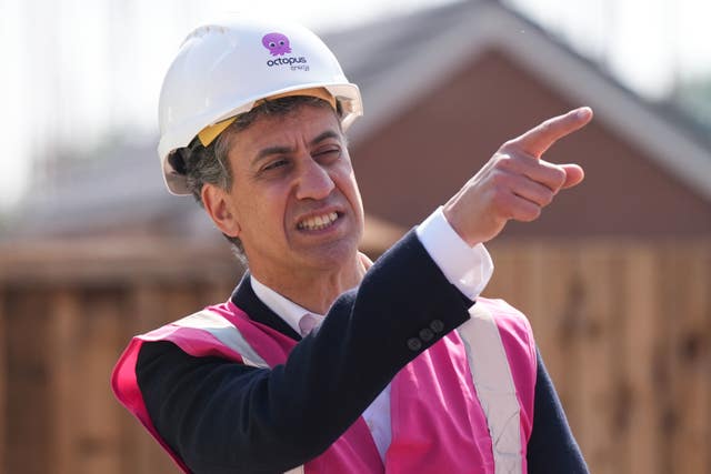 Shadow secretary of state for energy security and net zero Ed Miliband pointing while wearing a hard hat and pink hi-vis