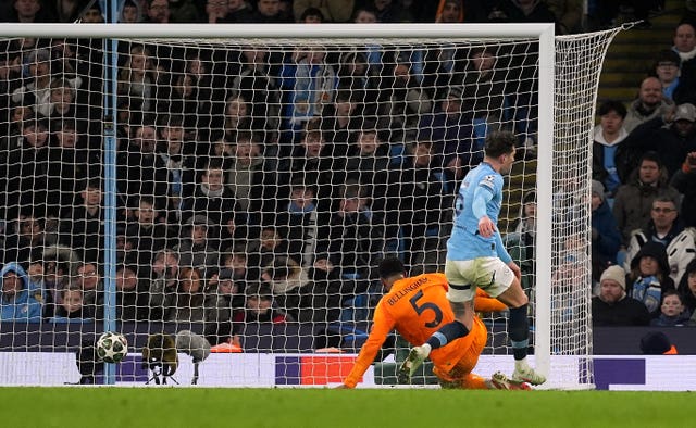 Jude Bellingham scores Real Madrid’s winner, left, scores Real Madrid's winner ahead of Manchester City defender John Stones