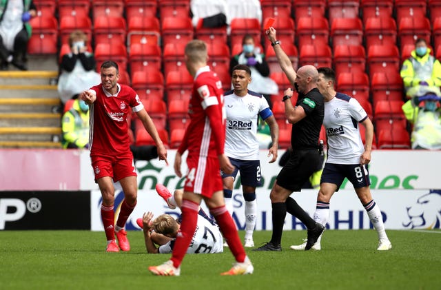 Aberdeen’s Andrew Considine (left) is shown a red card