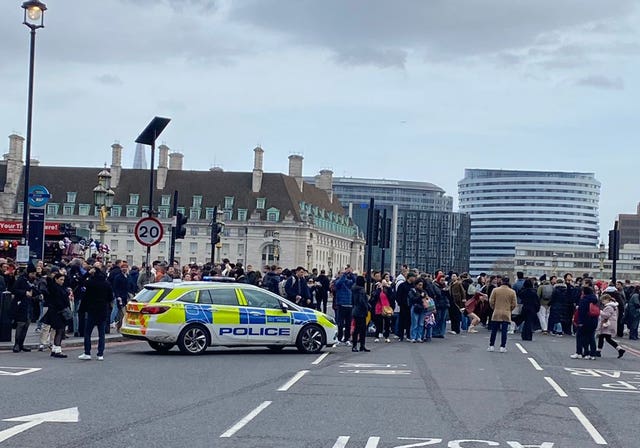 A crowd behind a cordon on Westminster Bridge after a stabbing