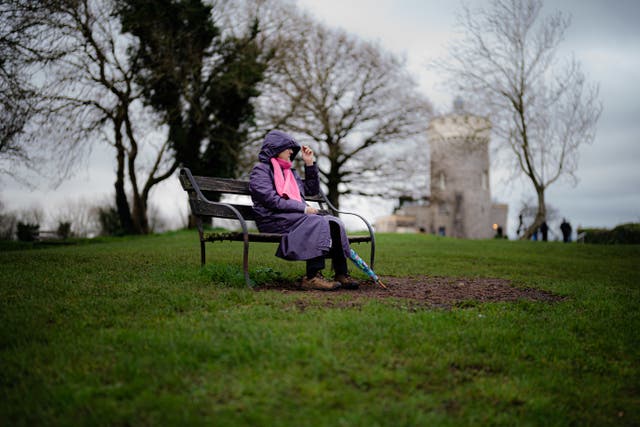 People sit on benches in Clifton, Bristol, during a break in the rain