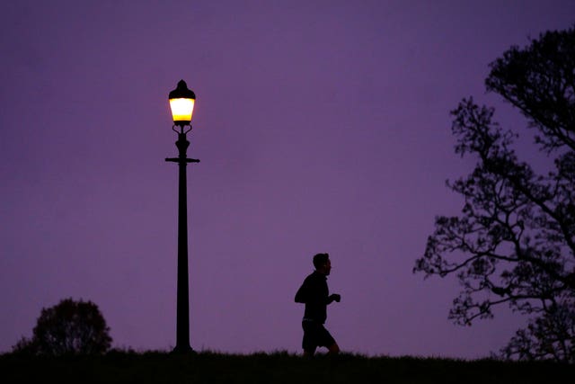 A man jogging during misty weather in Primrose Hill, London