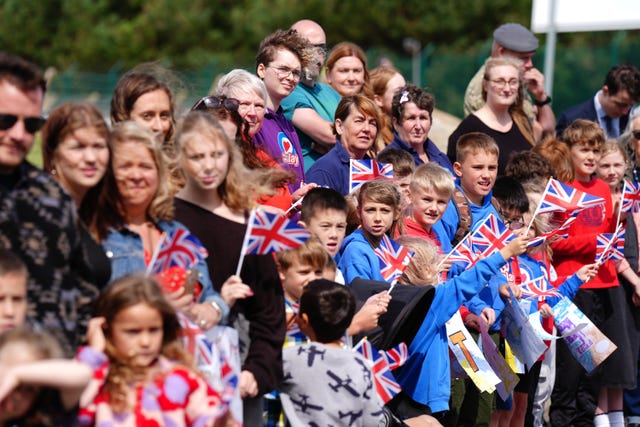 Members of the public waving Union flags outside RAF Lossiemouth in Moray