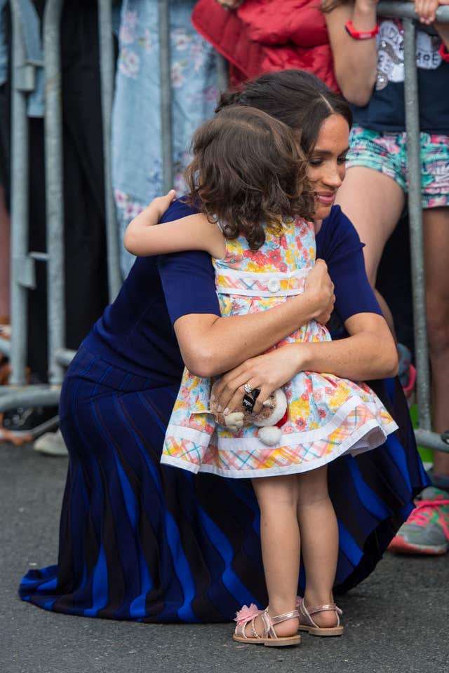The Duchess of Sussex hugged a young girl during a walkabout in Rotorua