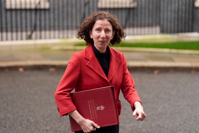 Anneliese Dodds leaves a Cabinet meeting in Downing Street carrying a red folder under her arm. She wears a red jacket.