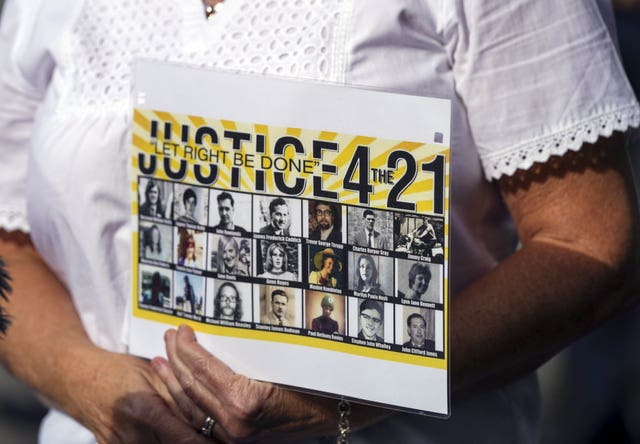 Julie Hambleton holds up a sign while speaking to media (Steve Parsons/PA)