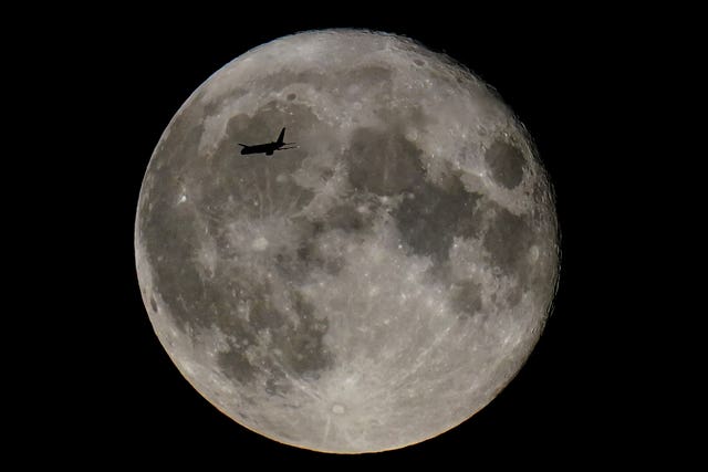 A plane passes in front of a supermoon