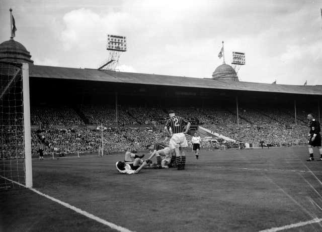 Players rush to the aid of goalkeeper Bert Trautmann in the 1956 FA Cup final