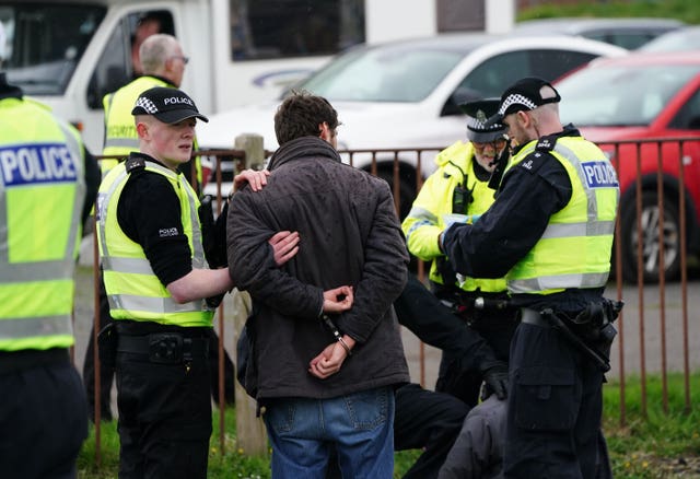 Animal Rising activists are apprehended by police officers as they attempted to invade the track at Ayr