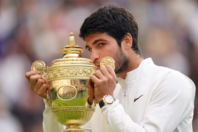 Carlos Alcaraz kisses the Wimbledon trophy