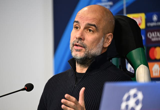 Pep Guardiola speaks into a microphone during a press conference