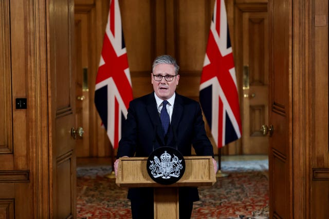 Sir Keir Starmer speaking from a lectern in Number 10, with British flags in the background