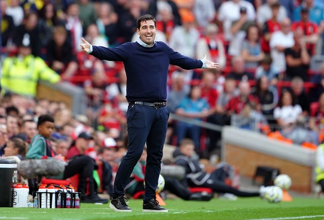 Bournemouth boss Andoni Iraola holds his arms out on the touchline at Anfield