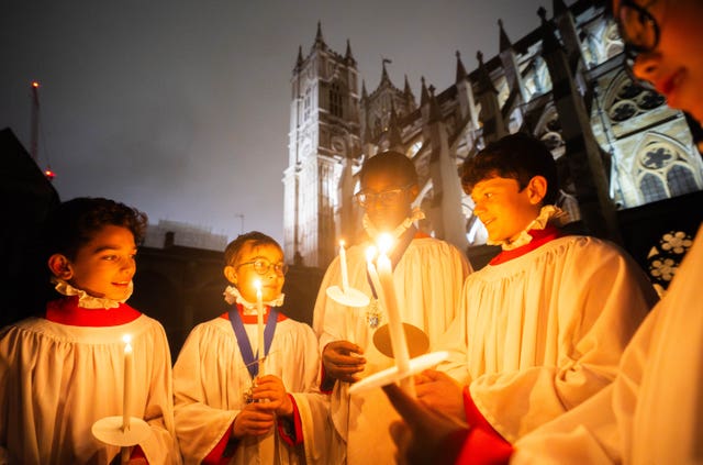 Choristers from the Westminster Abbey Choir lighting candles