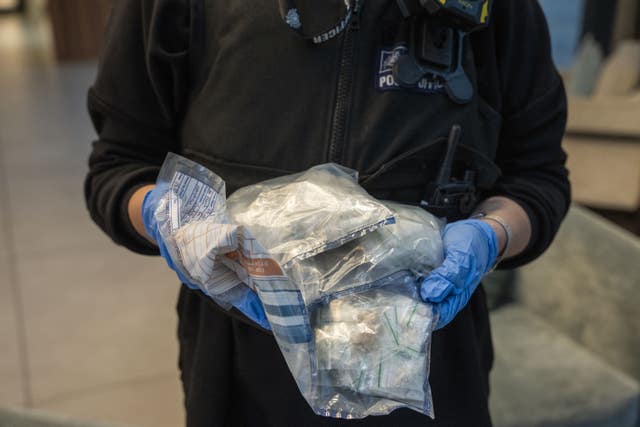 Police holding bags of drugs