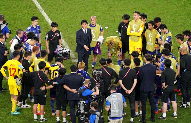 Japan manager Hajime Moriyasu speaks to his players following the defeat