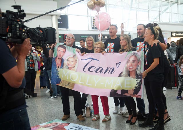 Love Island winners Amber Gill and Greg O'Shea and contestants Molly Mae  Hague and Tommy Fury (rear left to right) greet fans as they arrive at  Stansted Airport in Essex following the