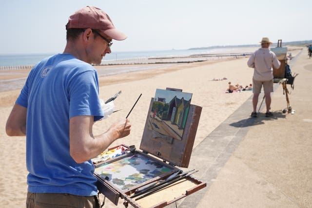 Artists painting the beach huts on Blyth beach in Northumberland