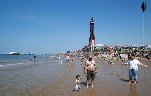 People enjoy the hot weather on the beach at Blackpool ( Martin Rickett/PA)