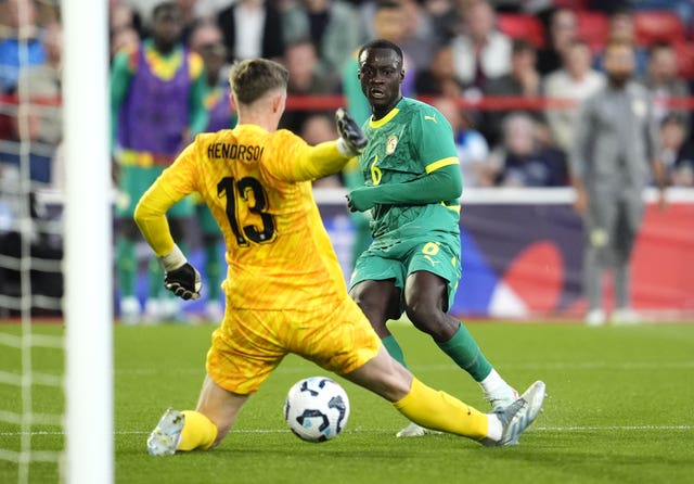 Senegal’s Habib Diarra scores through the legs of England keeper Dean Henderson
