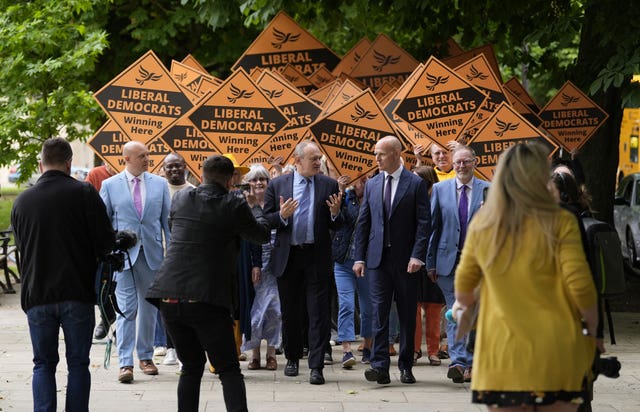 Liberal Democrat leader Sir Ed Davey (centre) chats with Liberal Democrat prospective parliamentary candidate for Cheltenham Max Wilkinson (centre right) during a visit to the town centre in Cheltenham, Gloucestershire