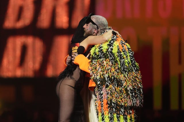 Charli XCX being congratulated by Teddy Swims, who presented her with album of the year 