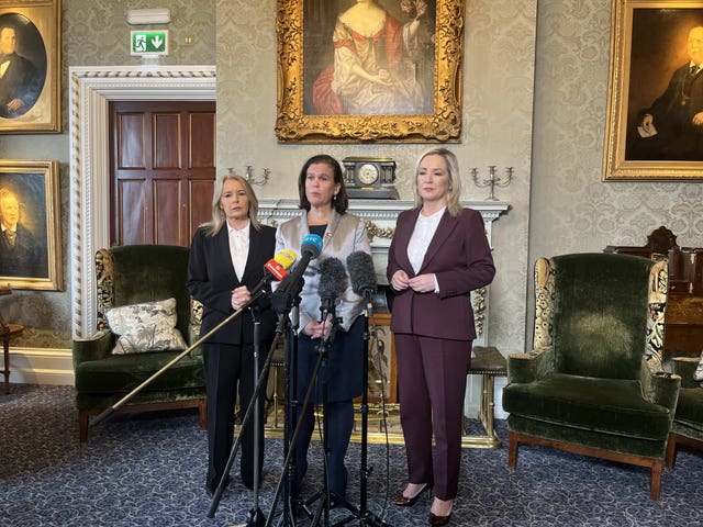 From left, Pat Cullen, Mary Lou McDonald and Michelle O'Neill standing behind microphones at The Culloden Hotel in Belfast