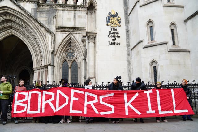 Protesters outside the the Royal Courts Of Justice in London for Wednesday's hearing holding a banner