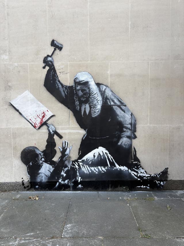 An artwork by Banksy at the Royal Courts of Justice in London which shows a judge attacking a protester with a gavel