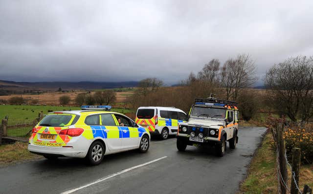A Mountain Rescue 4×4 passes two North Wales Police cars that closed the road
