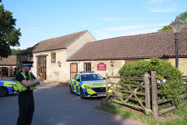 A police officer stands guard at Johnsons of Old Hurst