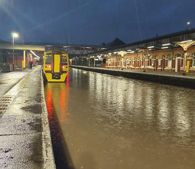 Flood water rises up to a platform at at Wellington station in Shropshire